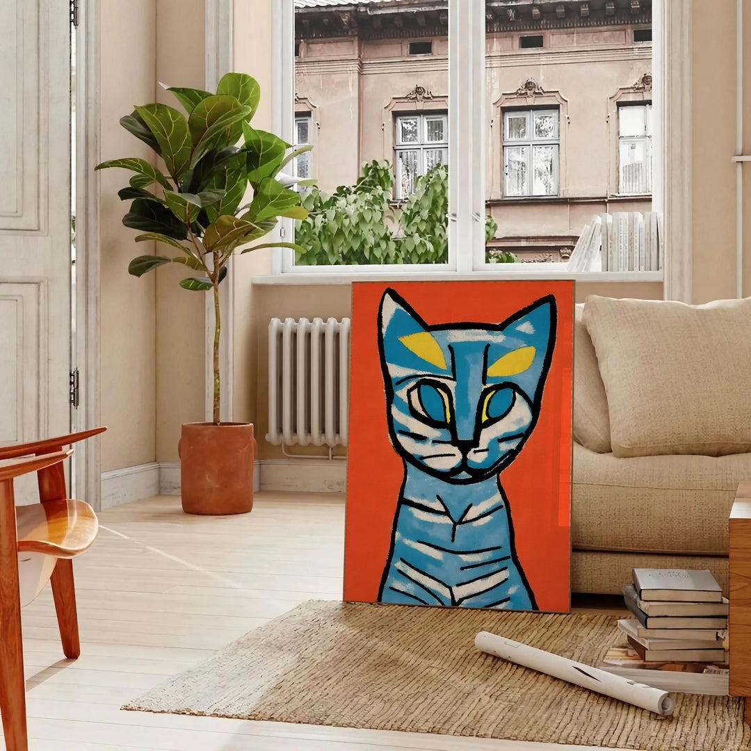 A modern art print featuring a stylized cat in blue and brown tones - in a Parisian living room with a sofa and a fig plant