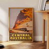 Illustration of Central Australia with warm oranges and earthy tones - beside a round wooden side table with books