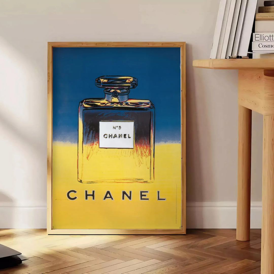 Chanel Pub Poster featuring a stylish design in gray and blue tones - beside a round wooden side table with books