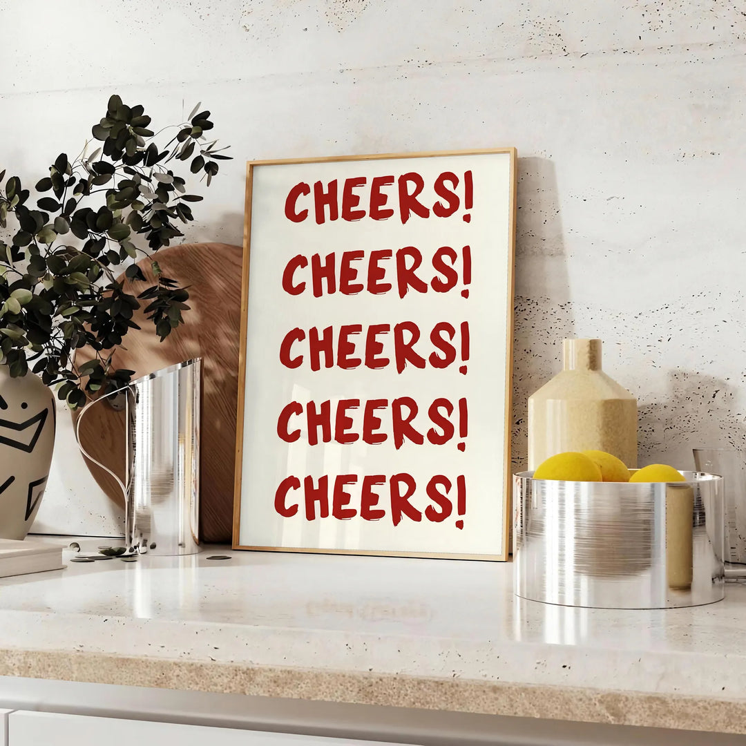 シンプルなデザインで「Cheers」の文字がグレーとホワイトで表現されています - ユーカリとレモンのボウルを添えたカウンターに