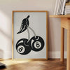 Graphic illustration of cherries in a pop art style with black and blue hues - beside a round wooden side table with books
