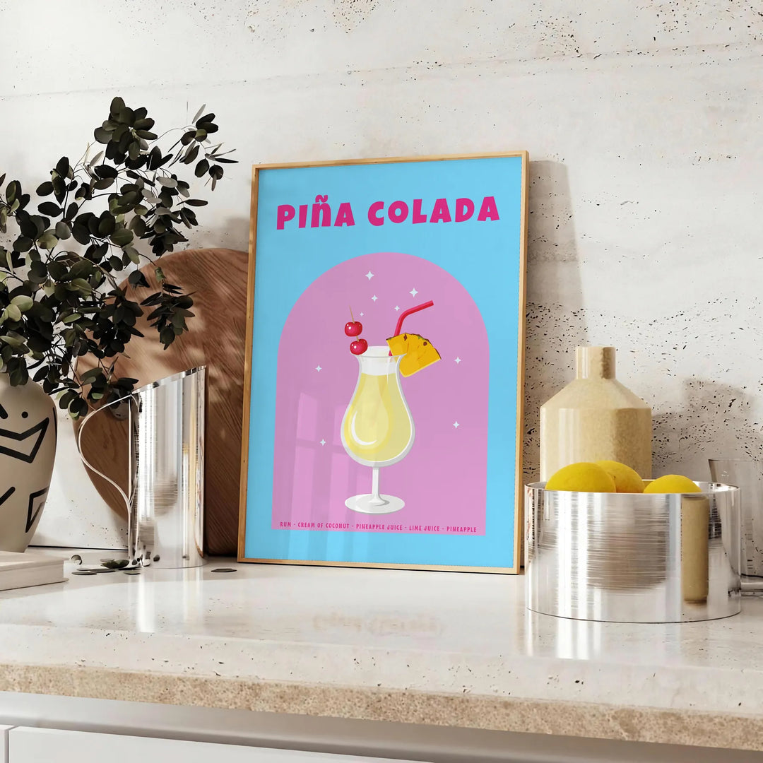Affiche vibrante teintes marron orange exotisme cocktail Piña Colada espace cadeau une version cadre œuvre unique - sur un plan de travail avec eucalyptus et coupe de citrons