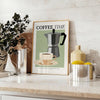 A kitchen scene featuring coffee cups and beans in a modern style with black and blue tones - styled on a counter with eucalyptus and a bowl of lemons