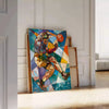 Cubist artwork featuring abstract shapes in shades of gray and green - leaning on a herringbone floor against a white panelled wall