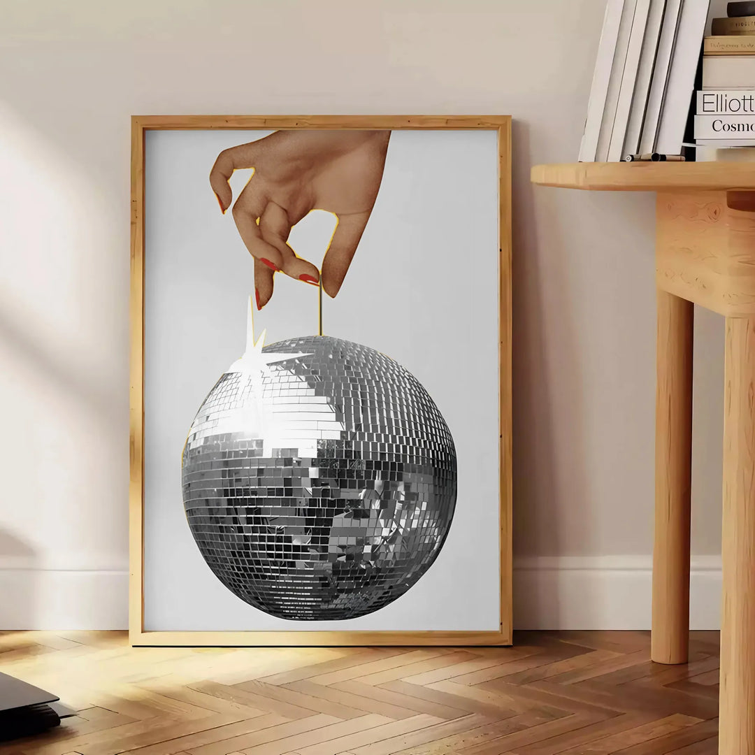 A graphic illustration of a hand making a disco gesture, featuring green and blue hues - beside a round wooden side table with books