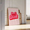 Colorful retro-style poster with the phrase 'Don't Be A Dick' in bold letters - leaning on a herringbone floor against a white panelled wall