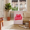 Colorful retro-style poster with the phrase 'Don't Be A Dick' in bold letters - in a Parisian living room with a sofa and a fig plant
