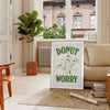 Playful donut illustration with groovy text in pastel colors - in a Parisian living room with a sofa and a fig plant