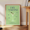 Un cocktail dry martini in un bicchiere con tonalità verdi e blu - accanto a un tavolino rotondo in legno con libri