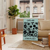 abstract representation of planets against a dark blue backdrop - in a Parisian living room with a sofa and a fig plant