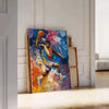 Abstract expressionist artwork with green and blue color splashes - leaning on a herringbone floor against a white panelled wall