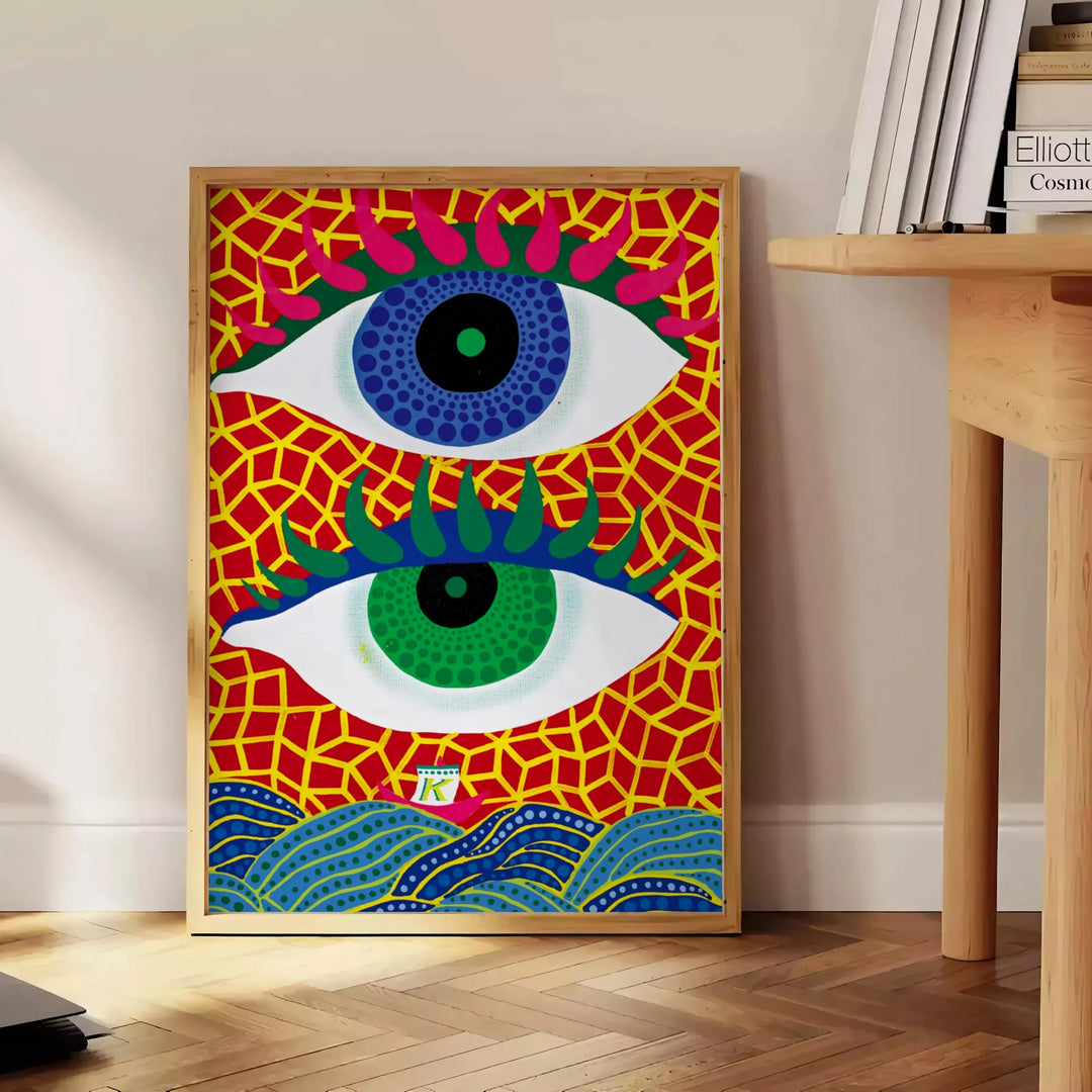 Occhi astratti in blu e arancione di Yayoi Kusama - accanto a un tavolino rotondo in legno con libri