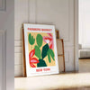 Botanical illustration featuring fresh greens and rich oranges from a farmer's market - leaning on a herringbone floor against a white panelled wall