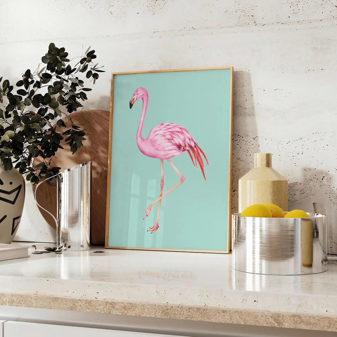 A pink flamingo standing gracefully against a black and orange background - styled on a counter with eucalyptus and a bowl of lemons