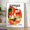 Vintage travel poster featuring Florida's iconic palm trees and sun, with warm earth tones - in a bright minimalist room with a plant and an armchair