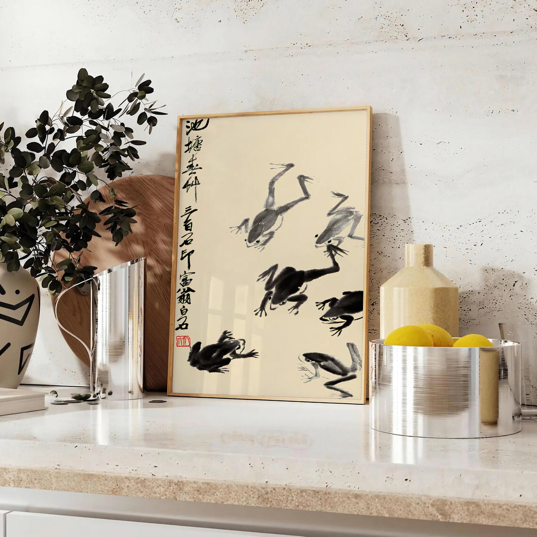 A stylized frog illustration in black and orange, inspired by Matsumoto Hoji, Japan - styled on a counter with eucalyptus and a bowl of lemons