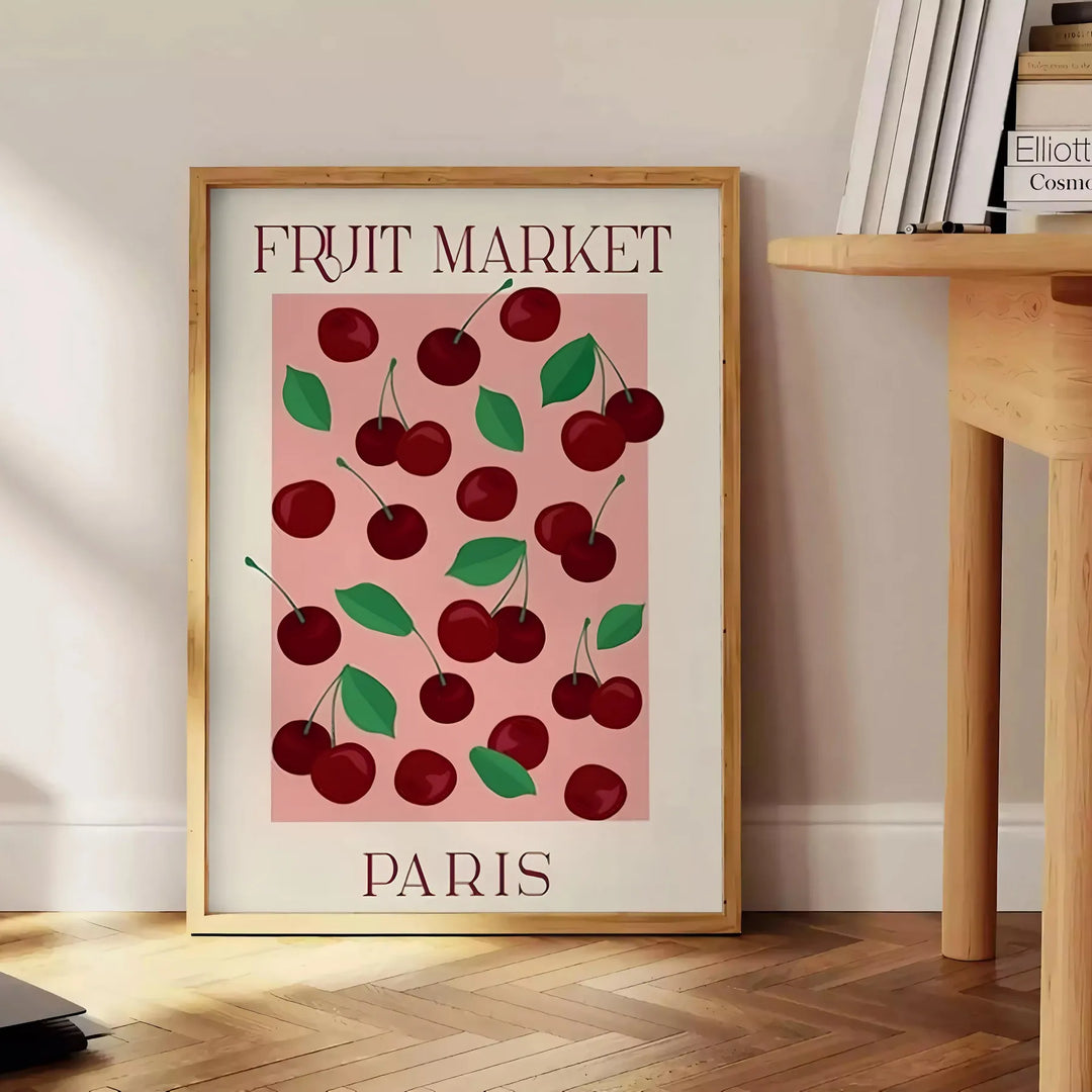 A graphic depiction of a fruit market in Paris with warm brown and orange tones - beside a round wooden side table with books