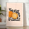 Färgglad fruktillustration med svart bakgrund och orange detaljer - i ett ljust minimalistiskt rum med växt och fåtölj
