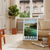 A serene depiction of Mount Fuji surrounded by green hills and gray skies - in a Parisian living room with a sofa and a fig plant