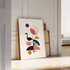 Geometric shapes in black and orange on a minimal background - leaning on a herringbone floor against a white panelled wall
