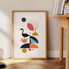 Geometric shapes in black and orange on a minimal background - beside a round wooden side table with books
