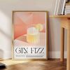 Abstract splash of orange and black depicting a Gin Fizz cocktail - beside a round wooden side table with books