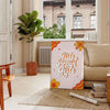 Illustration of diverse girls supporting each other in warm brown and orange tones - in a Parisian living room with a sofa and a fig plant