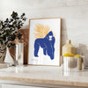 A detailed illustration of a gorilla surrounded by green and blue foliage - styled on a counter with eucalyptus and a bowl of lemons