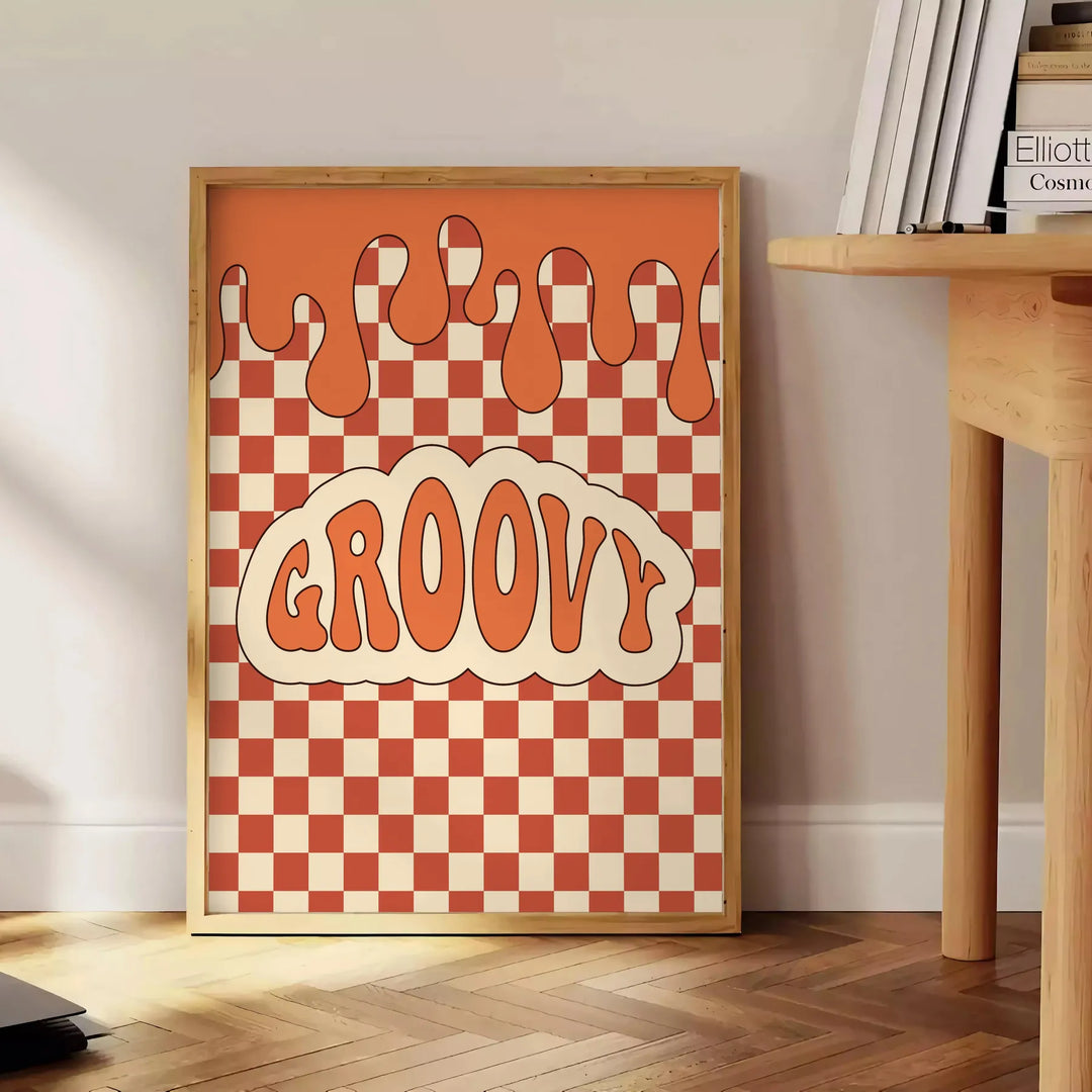 Retro-style poster featuring abstract shapes in orange and brown tones - beside a round wooden side table with books