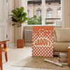 Retro-style poster featuring abstract shapes in orange and brown tones - in a Parisian living room with a sofa and a fig plant