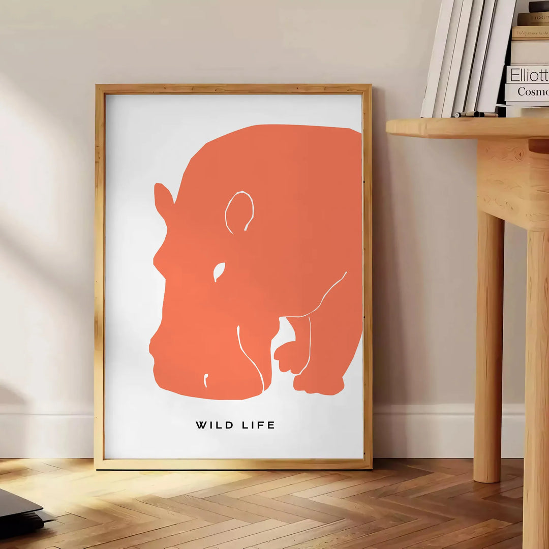 A black and orange hippopotamus in a natural setting, wildlife art - beside a round wooden side table with books