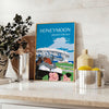 A romantic travel poster featuring a couple on a honeymoon, with blue and black tones. - styled on a counter with eucalyptus and a bowl of lemons