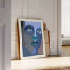 Abstract representation of a human figure in bold colors and shapes - leaning on a herringbone floor against a white panelled wall