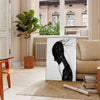 Abstract human figure in bohemian style with gray and black tones - in a Parisian living room with a sofa and a fig plant