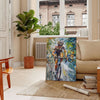 Impressionist landscape with lush greens and tranquil blues - in a Parisian living room with a sofa and a fig plant