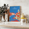 Vintage travel poster featuring Florence, Italy with lush green hills and blue skies - styled on a counter with eucalyptus and a bowl of lemons