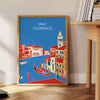 Vintage travel poster featuring Florence, Italy with lush green hills and blue skies - beside a round wooden side table with books