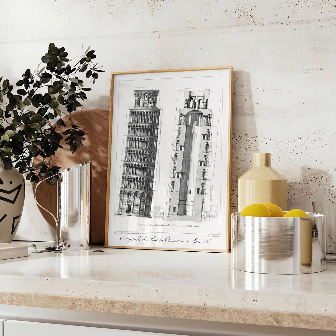 Travel poster featuring the Leaning Tower of Pisa in gray and white tones - styled on a counter with eucalyptus and a bowl of lemons