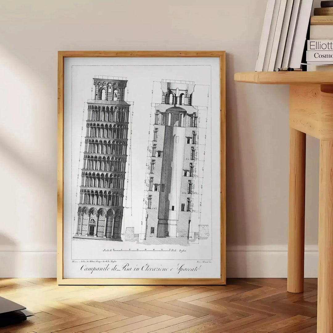 Travel poster featuring the Leaning Tower of Pisa in gray and white tones - beside a round wooden side table with books