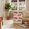 A jaguar illustrated in bold orange and gray tones against a textured background - in a Parisian living room with a sofa and a fig plant