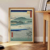 A serene landscape featuring lush green hills and a blue sky in Japan - beside a round wooden side table with books
