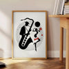 Dynamic jazz dancers in motion against an orange and white background - beside a round wooden side table with books