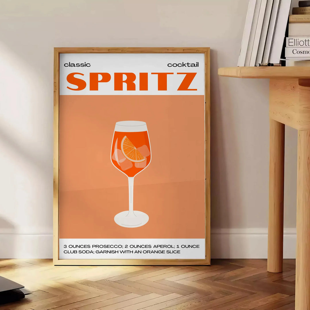 A sleek black background with a vibrant orange cocktail spritz illustration - beside a round wooden side table with books