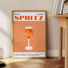 A sleek black background with a vibrant orange cocktail spritz illustration - beside a round wooden side table with books
