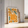 A colorful kitchen scene with greens and oranges, featuring utensils and food items - leaning on a herringbone floor against a white panelled wall
