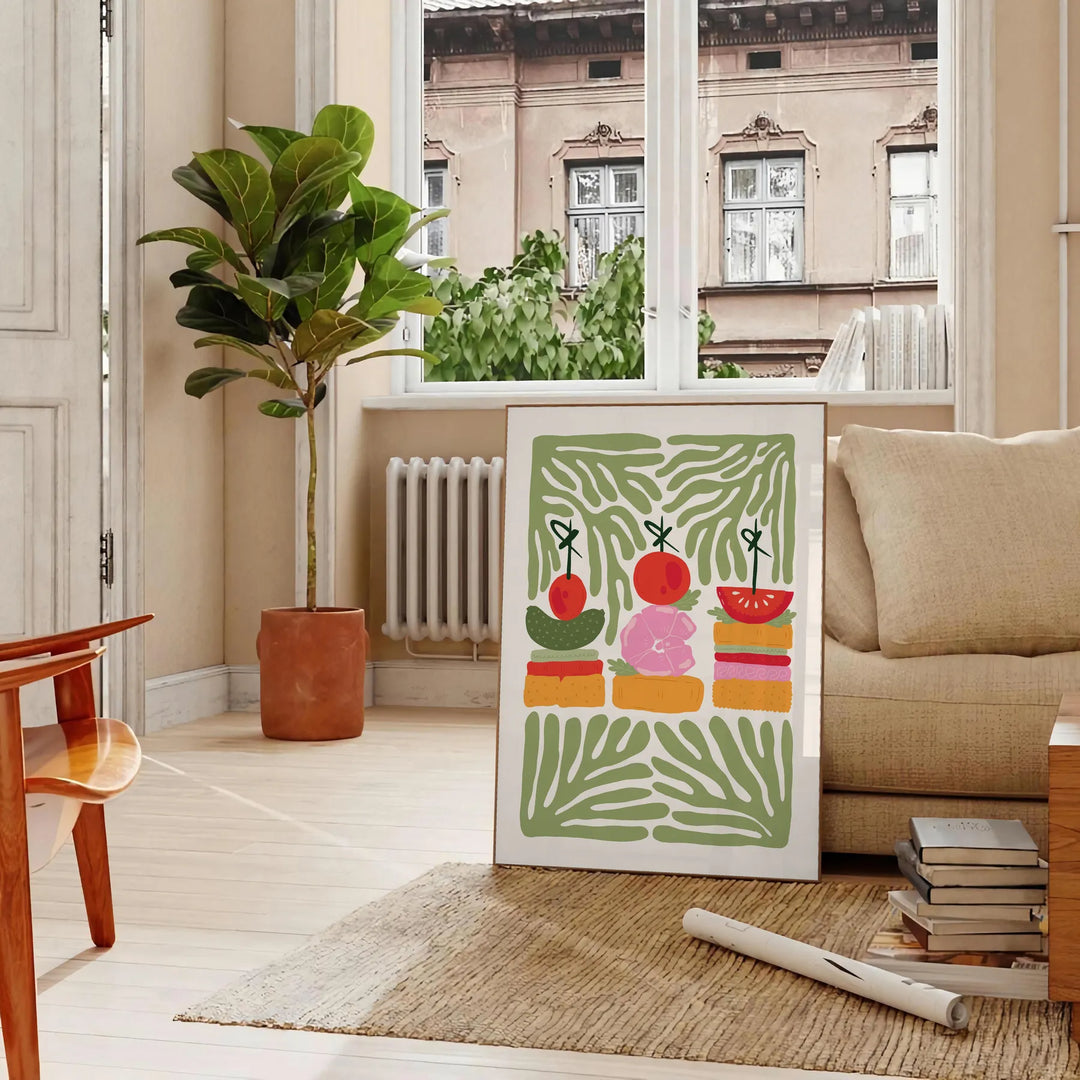 A colorful kitchen print featuring shades of green and orange - in a Parisian living room with a sofa and a fig plant
