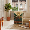 Stylized cyclist racing through green and brown landscapes for Tour de France - in a Parisian living room with a sofa and a fig plant