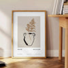 Colorful boho poster featuring abstract shapes and patterns in green and black - beside a round wooden side table with books