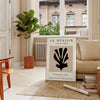 Maximalist design featuring bold black and orange colors in an abstract composition - in a Parisian living room with a sofa and a fig plant