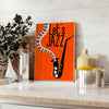 Maximalist poster featuring bold orange and black abstract shapes with jazz elements - styled on a counter with eucalyptus and a bowl of lemons